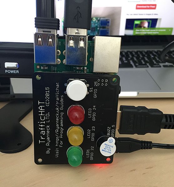 Figure 1: The TrafficHAT module for the Raspberry Pi, which includes 3 LED lights, a buzzer, and push button, all of which are programmable via GPIO.